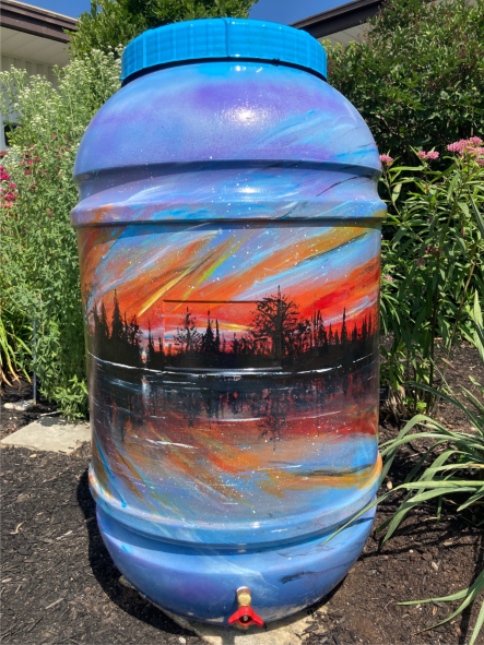 Photo of painted rain barrel sunset on pond.